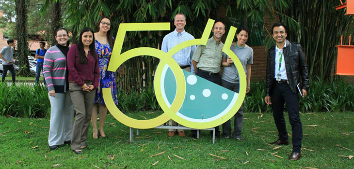 A group of UC representatives stand by a sign displaying the number 50