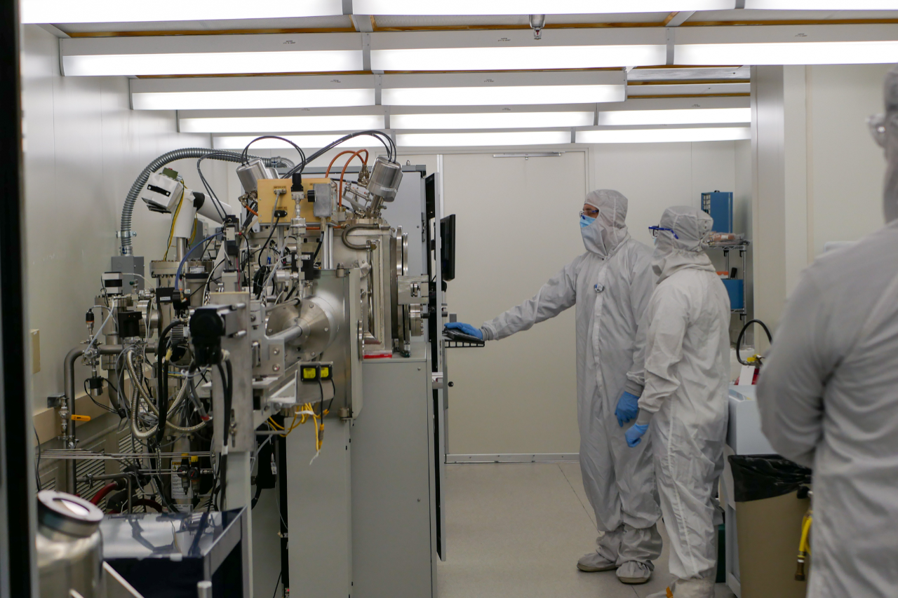 Two staff working on semi-conductors in the cleanroom lab